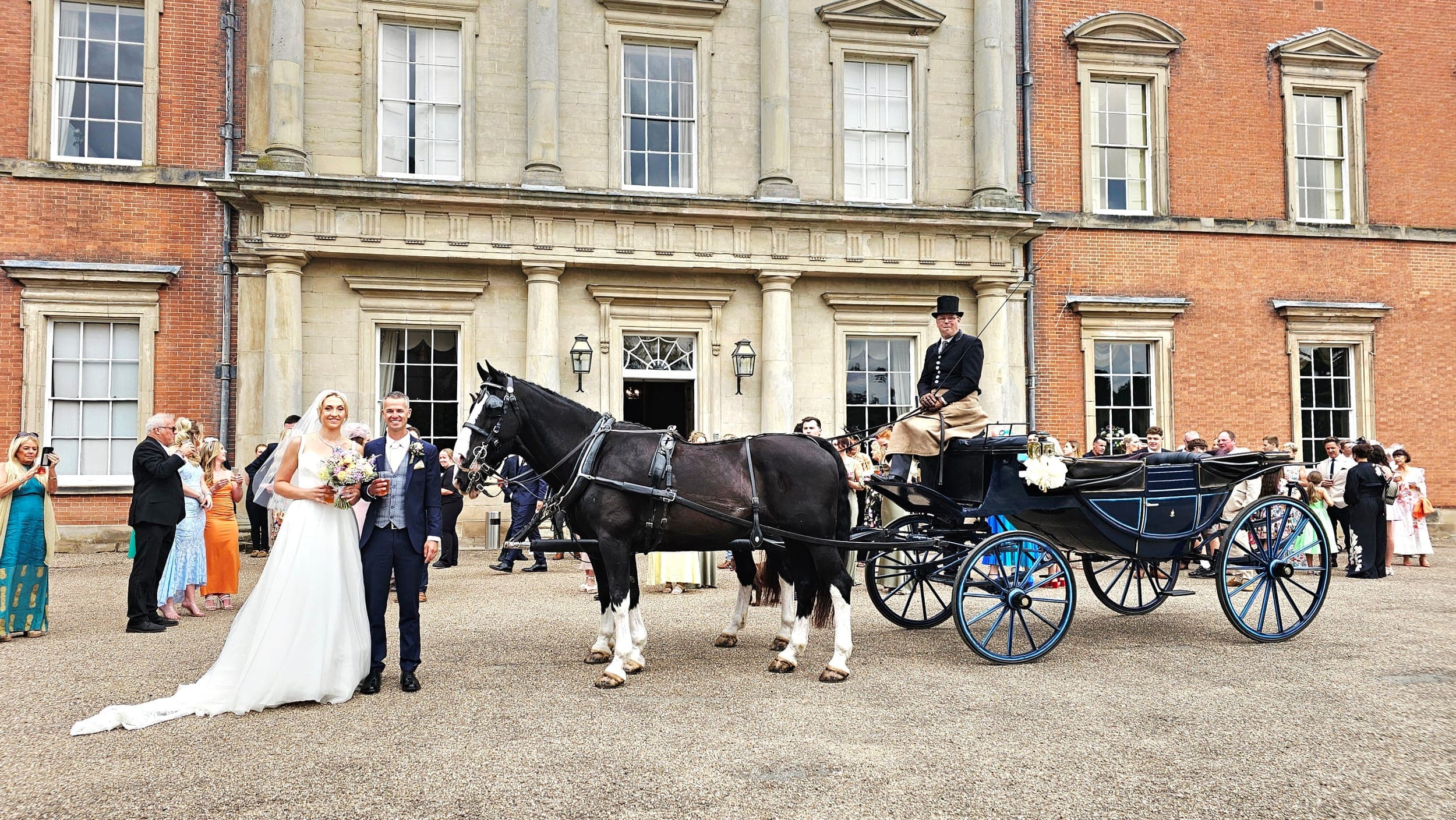 Bride and groom with black horse and blue Landau carriage at a Lincolnshire estate wedding