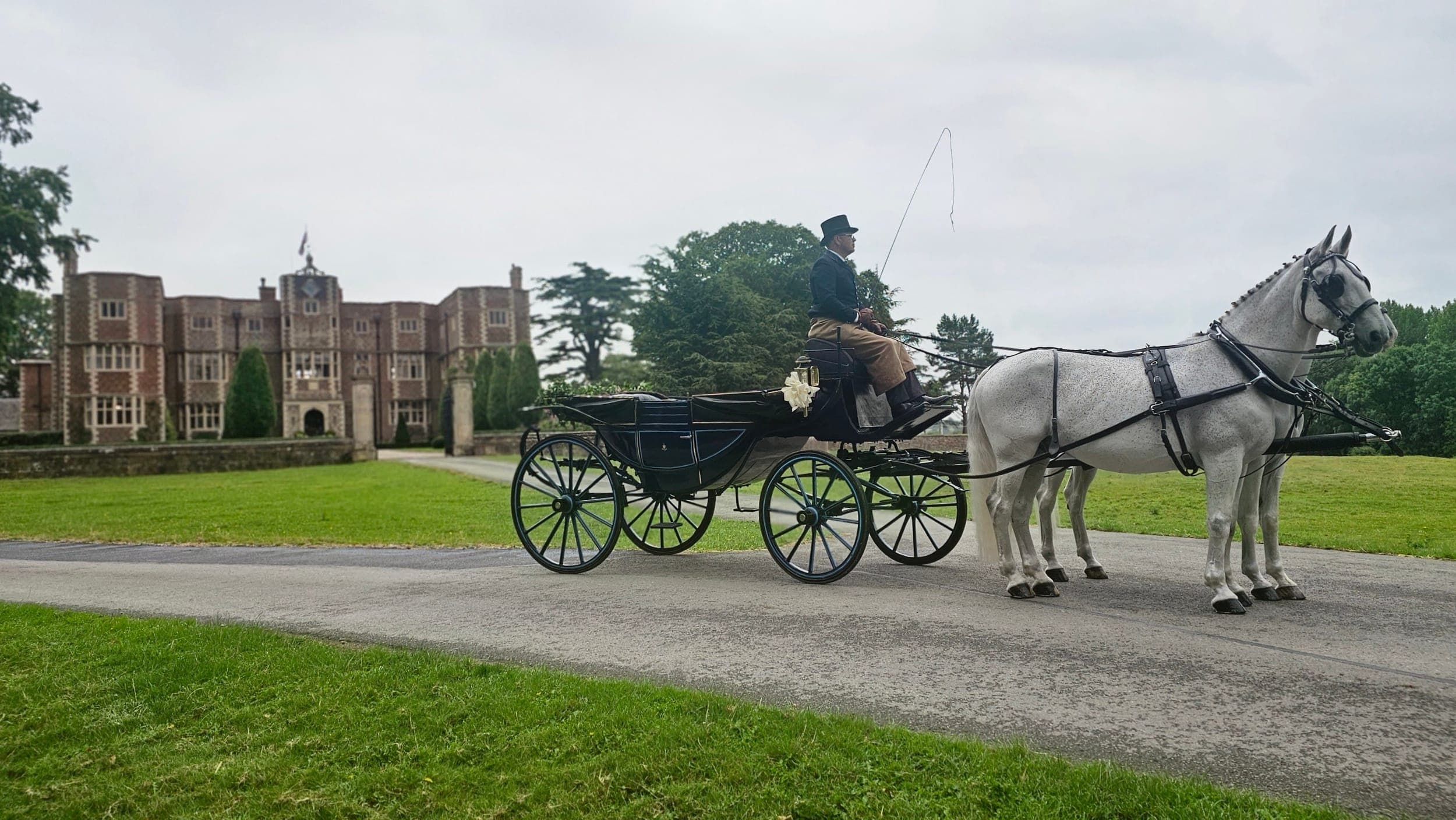 White horses drawing the open wagonette carriage at a Lincolnshire manor wedding